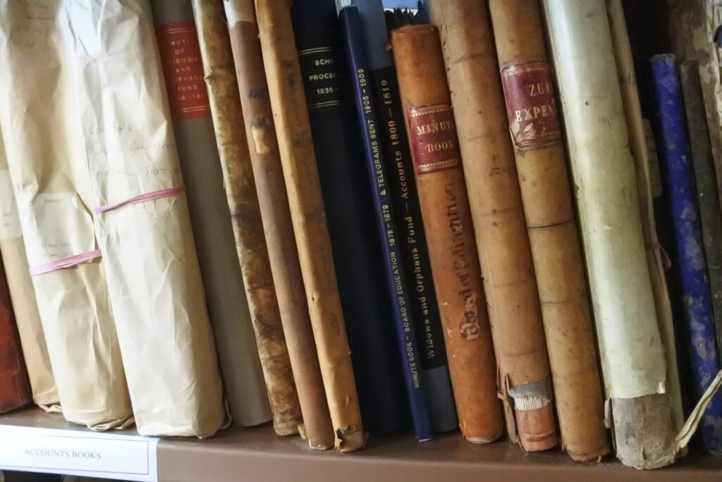 Bound ledgers shelved tightly together, spines worn and unlabelled.